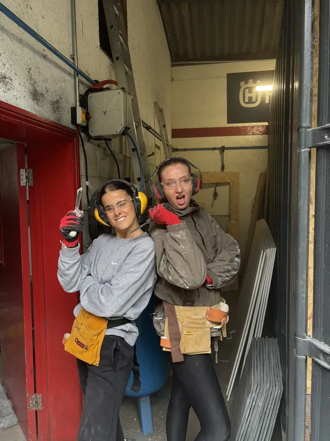 Georgie & Sarah - Doing probably the worst job of the build; peeling & sanding old paint off the walls. Kept the vibes high though!